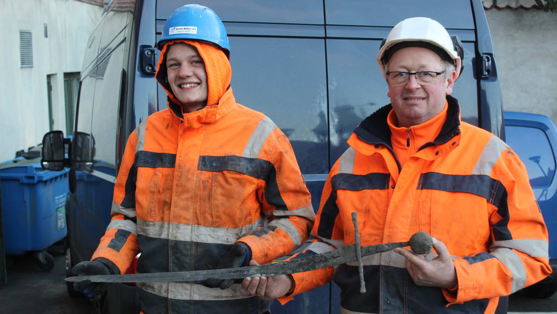 Pipe layer Jannick Vestergaard and engineer Henning Nøhr hold up the sword they found.
