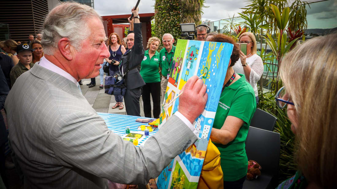 Prince Charles adds a flourish to a children's painting in Australia in 2018. 