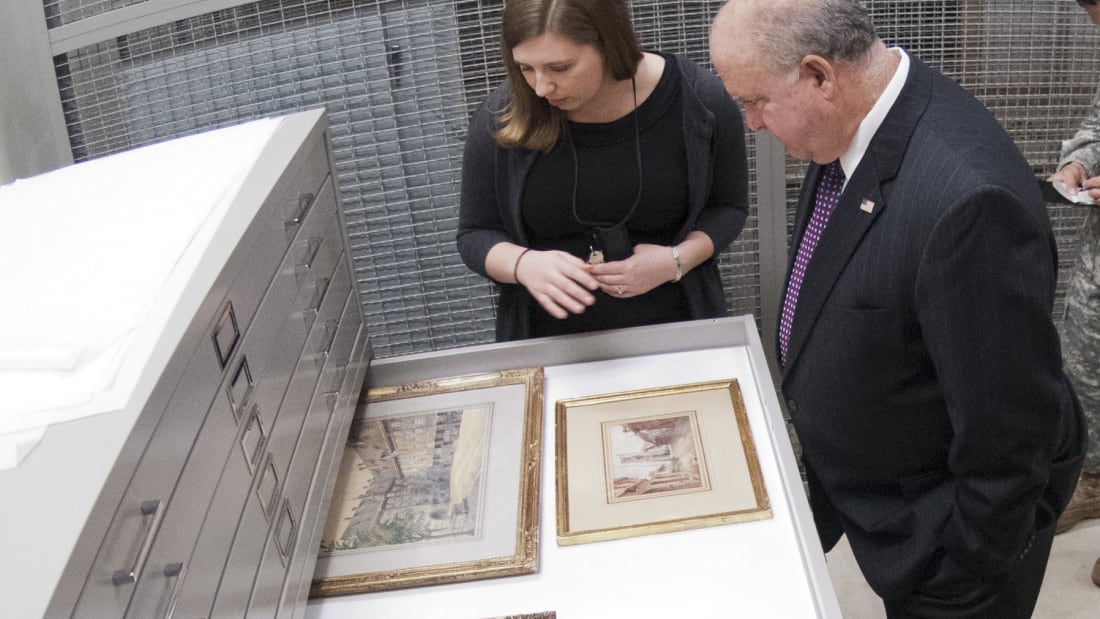 Art Curator Sarah Forgey shows Under Secretary of the Army Joseph W. Westphal four watercolors by Adolf Hitler at Fort Belvoir, Virginia. 