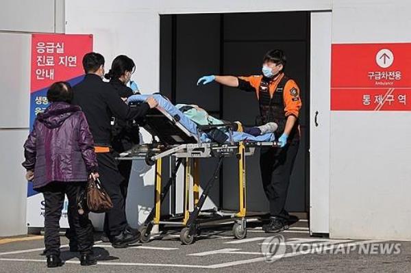 Officials move a patient to a hospital emergency room in Seoul on Nov. 8, 2024, amid a walkout by trainee doctors protesting the government's plan to increase the medical school enrollment quota. (Yonhap)