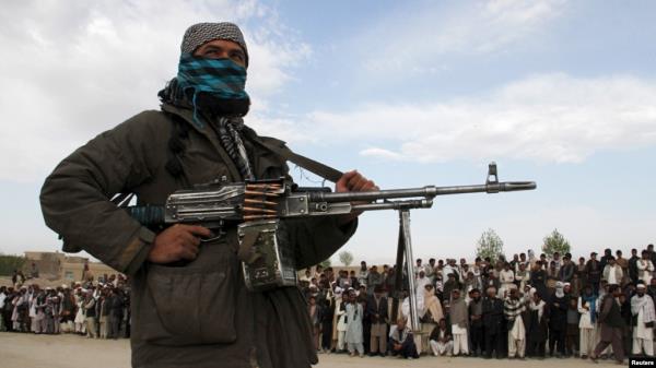 FILE - A member of the Taliban and other people stand at the site of a public execution in Ghazni province, Afghanistan, April 18, 2015. A co<em></em>nvicted murdered is scheduled to be executed on Nov. 13, 2024, in Gardez, in the country's Paktia province. 