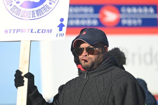 A man holds a picketing sign