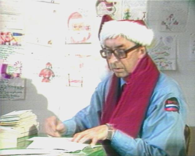 Man wearing Canada Post uniform and Santa Claus hat